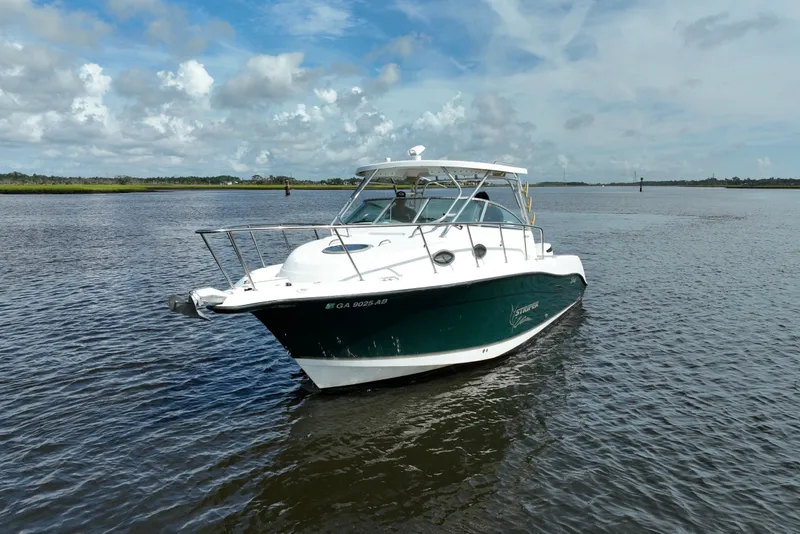Slide: The Image of 2004 Seaswirl Striper 2901 Walkaround O/B boat on calm water under cloudy sky. - 15
