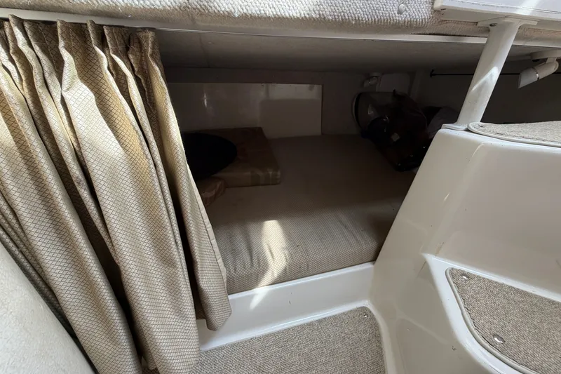 Slide: The Image of 2004 Seaswirl Striper 2901 Walkaround O/B cabin interior with beige curtains and carpeted flooring. - 33