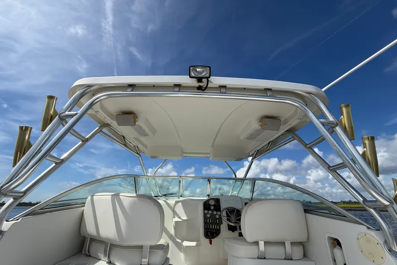 Slide: The Image of 2004 Seaswirl Striper 2901 Walkaround O/B boat interior with helm and seating under clear sky. - 27