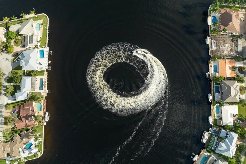 Slide: The Image of Aerial view of Valiatt 410HT boat creating circular wake in canal, surrounded by waterfront homes. - 14