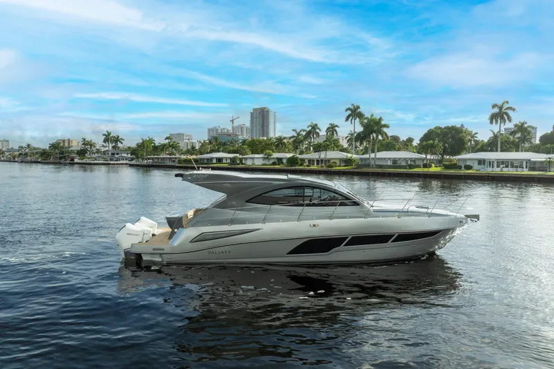 The Image of 2025 Valiatt 410HT luxury yacht cruising on a scenic waterfront with palm trees. - 1