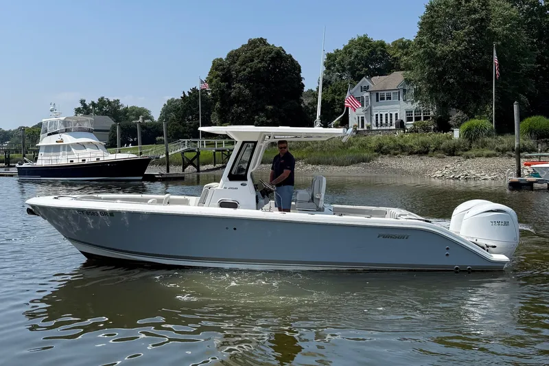 Slide: The Image of A modern 2026 Pursuit S 268 Sport boat on calm water, surrounded by houses. - 19