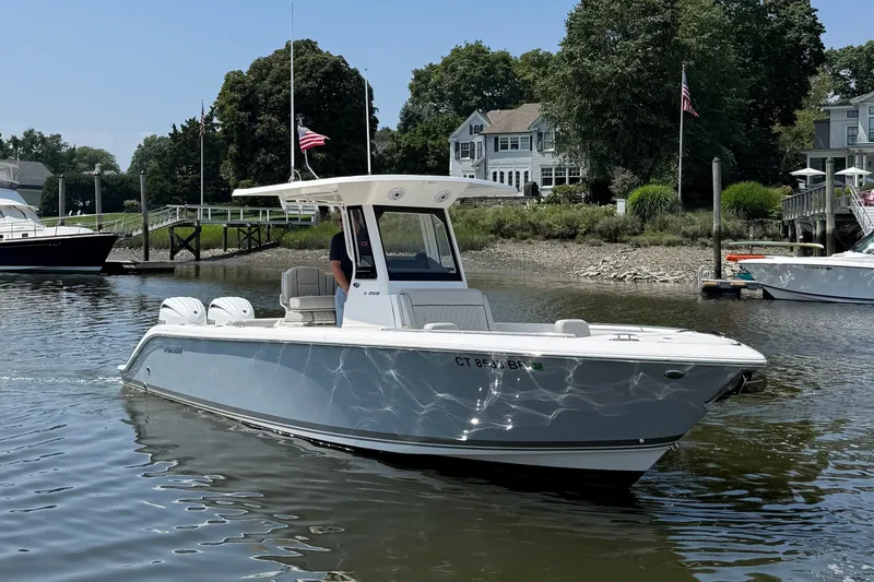 Slide: The Image of A sleek, modern boat with a white hull and T-top cruising on a calm river. - 18