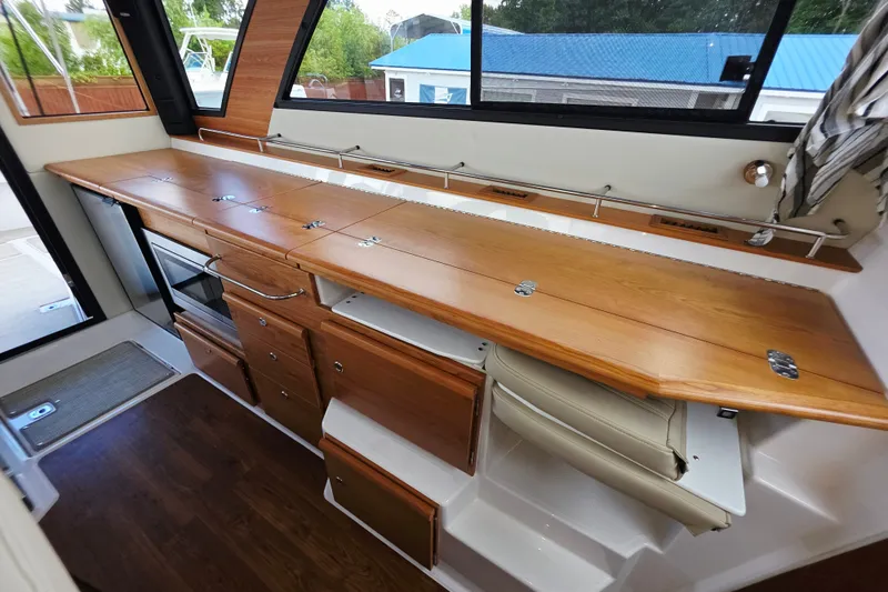 Slide: The Image of 2027 Cutwater C-32 Coupe interior with wooden cabinetry and modern appliances. - 12