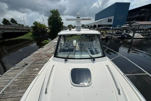 Slide: The Image of 2023 Boston Whaler 325 Conquest docked at marina under cloudy sky. - 58