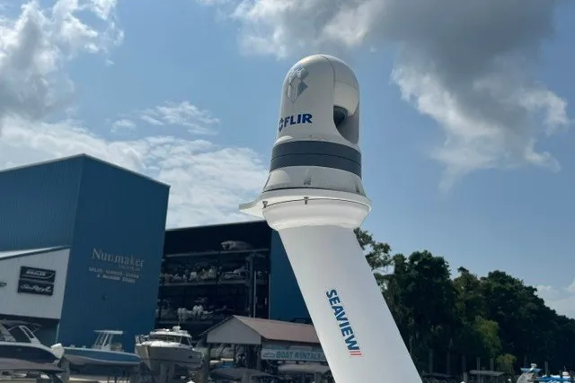 Slide: The Image of FLIR camera on 2023 Boston Whaler 325 Conquest, docked near blue building under cloudy sky. - 60