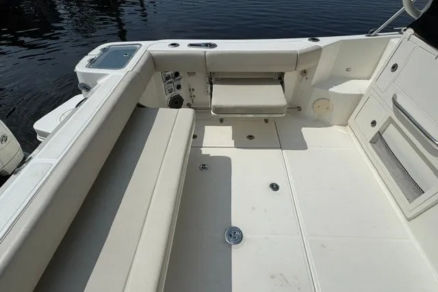 Slide: The Image of 2023 Boston Whaler 325 Conquest boat interior with cushioned seating and deck details. - 27