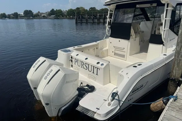 Slide: The Image of 2023 Boston Whaler 325 Conquest boat docked, featuring twin Mercury engines. - 21