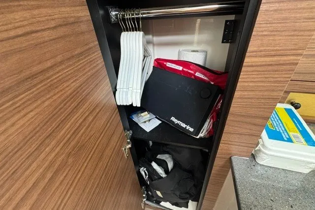 Slide: The Image of Storage cabinet in 2023 Boston Whaler 325 Conquest, featuring hangers and boating accessories. - 47