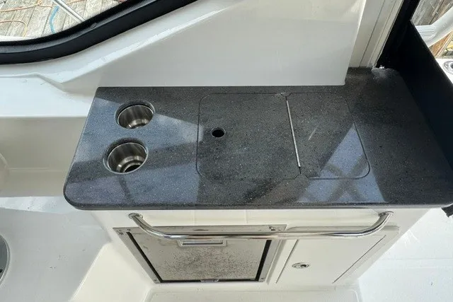 Slide: The Image of 2023 Boston Whaler 325 Conquest boat kitchenette with dual sinks and countertop. - 31