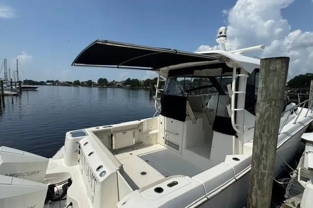 Slide: The Image of 2023 Boston Whaler 325 Conquest boat docked, featuring spacious deck and canopy. - 29