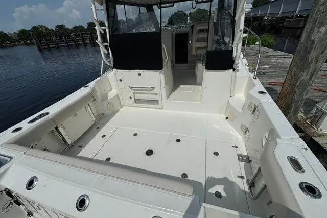 Slide: The Image of 2023 Boston Whaler 325 Conquest boat interior, featuring spacious deck and seating area. - 23
