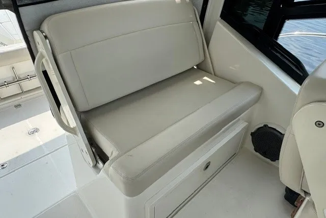 Slide: The Image of 2023 Boston Whaler 325 Conquest interior seating, featuring beige upholstery and sleek design. - 33