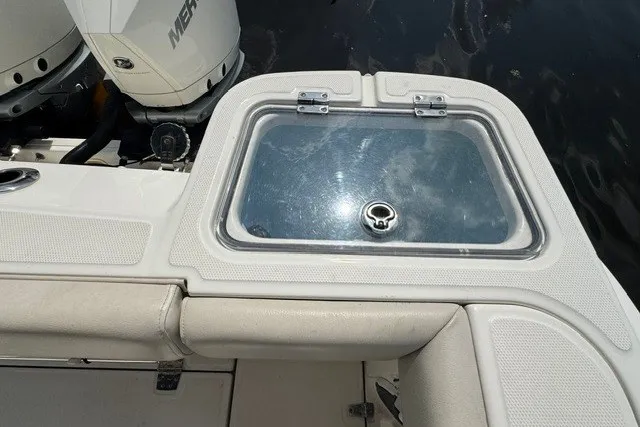 Slide: The Image of 2023 Boston Whaler 325 Conquest boat deck with storage compartment and Mercury engine. - 55