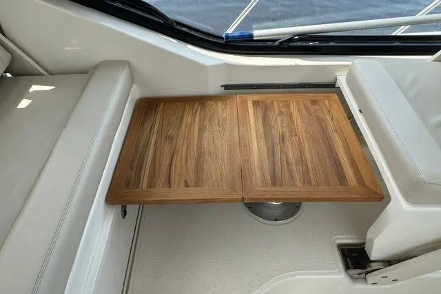 Slide: The Image of 2023 Boston Whaler 325 Conquest interior with wooden foldable table. - 36