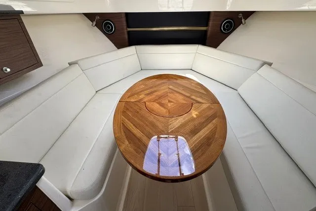 Slide: The Image of Interior of 2023 Boston Whaler 325 Conquest with elegant wood table and white seating. - 44