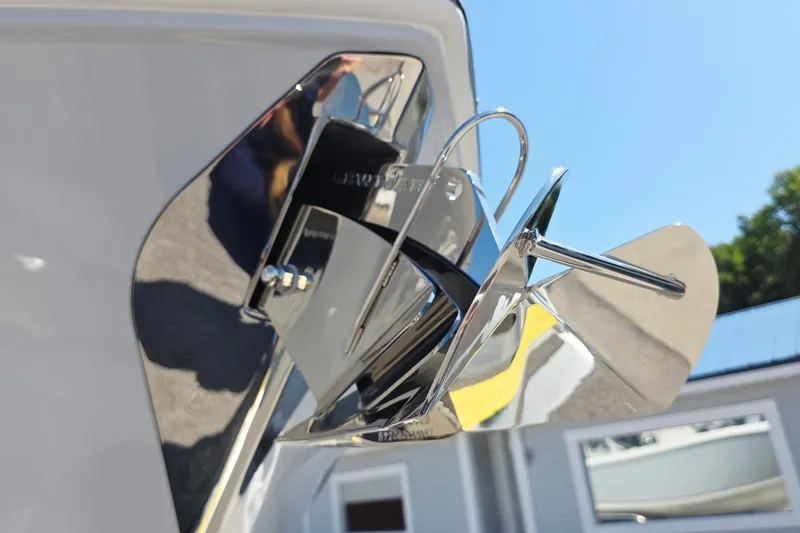 Slide: The Image of Close-up of a shiny anchor on a boat, surrounded by blue sky and buildings. - 21