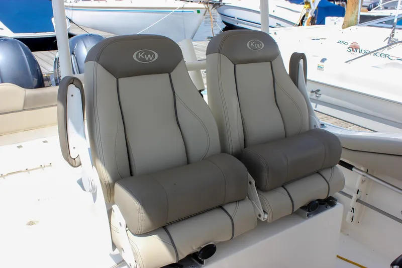 Slide: The Image of 2022 Key West 263 FS boat seats, featuring comfortable gray upholstery at a marina. - 19