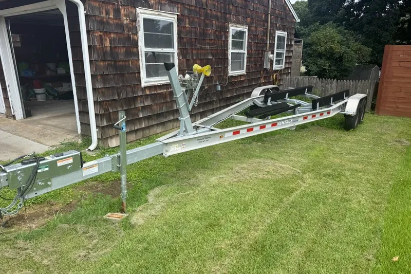 Slide: The Image of Trailer for 2022 Key West 263 FS boat parked beside a wooden garage. - 43