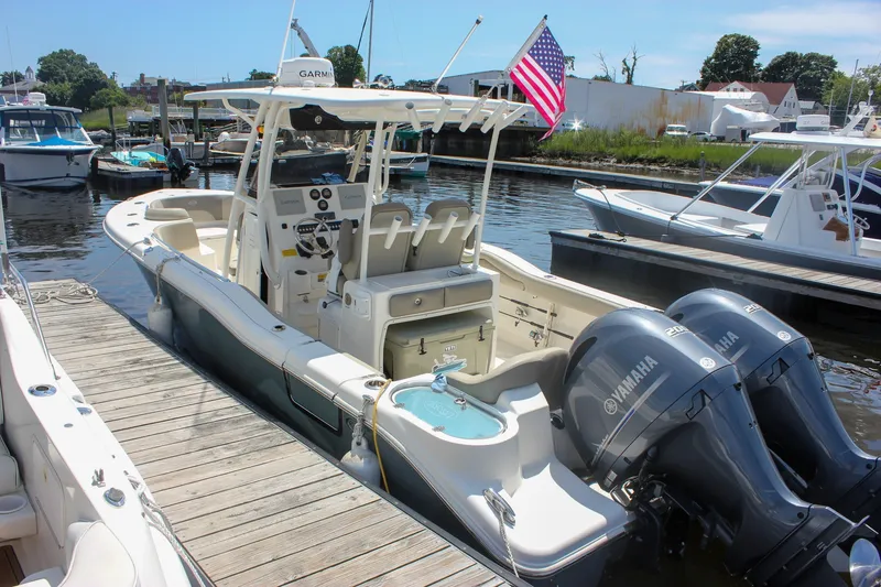 Slide: The Image of 2022 Key West 263 FS boat docked with twin Yamaha engines and American flag. - 1