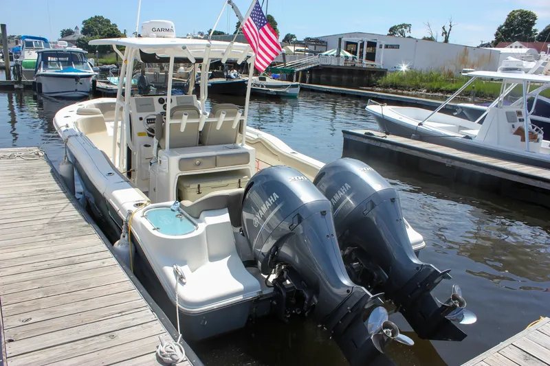 Slide: The Image of 2022 Key West 263 FS boat docked with twin Yamaha engines and American flag. - 42