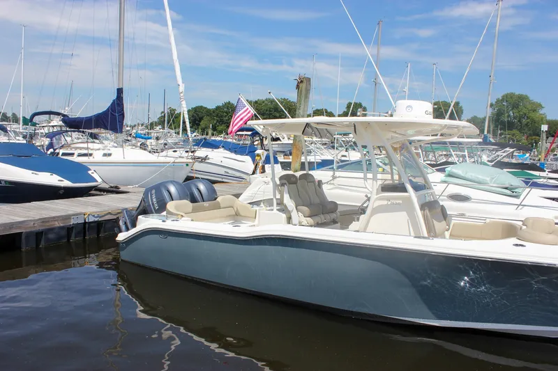 Slide: The Image of 2022 Key West 263 FS boat docked at a marina with sailboats in the background. - 49