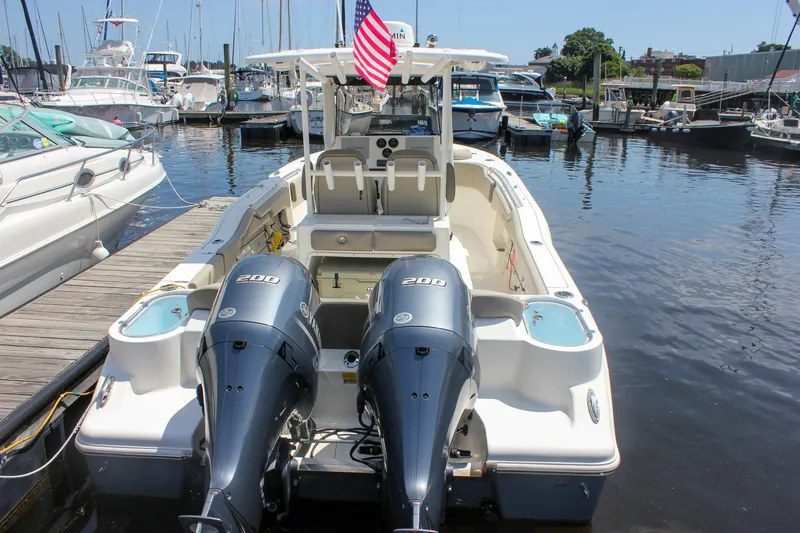 Slide: The Image of 2022 Key West 263 FS boat docked with dual 200 horsepower engines and American flag. - 2