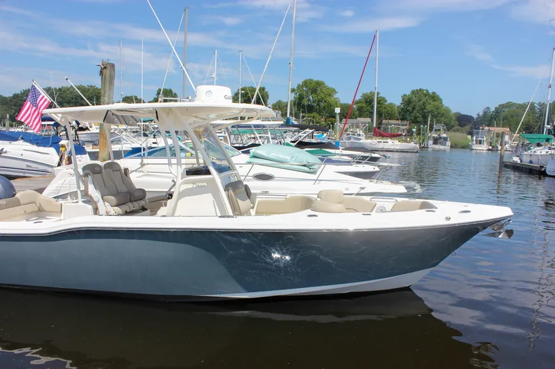 Slide: The Image of 2022 Key West 263 FS boat docked in a marina with other vessels. - 48
