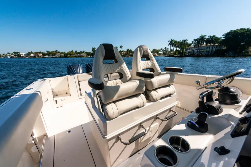 Slide: The Image of 2027 Sailfish 312 CC boat interior with luxurious seating and steering, on a sunny day. - 26