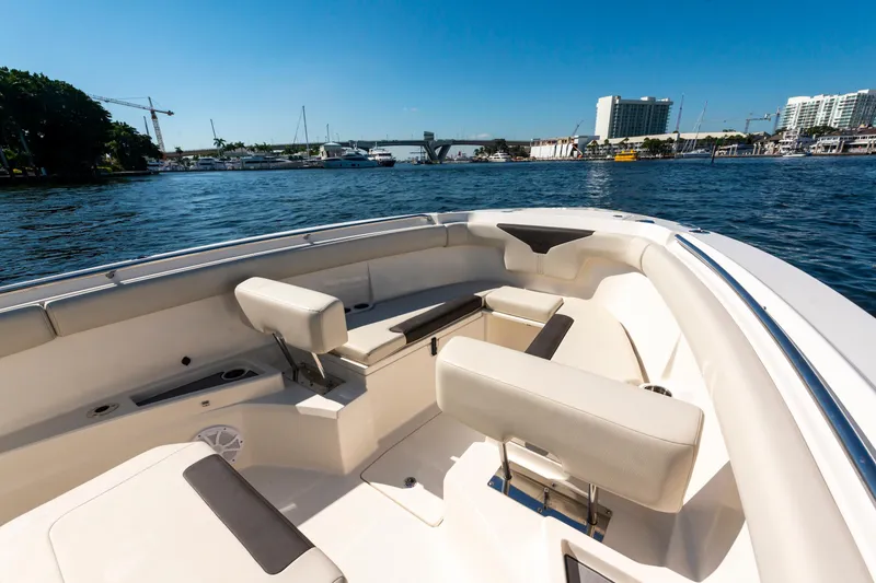 Slide: The Image of 2027 Sailfish 312 CC boat interior with seating, docked in a marina under clear blue skies. - 17
