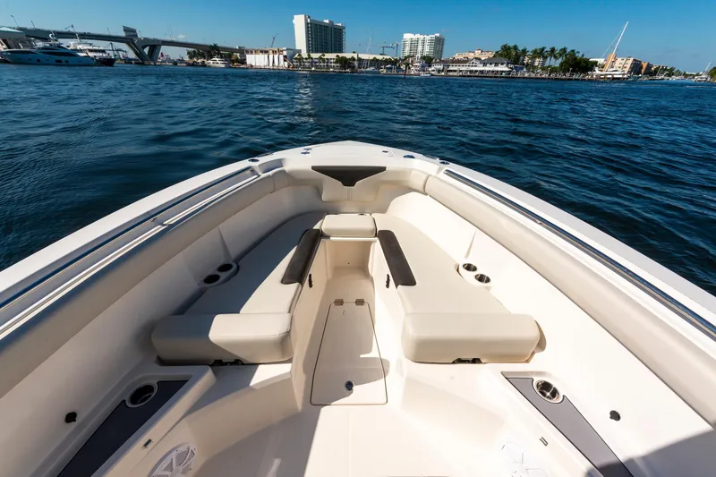 Slide: The Image of 2027 Sailfish 312 CC boat interior with seating, on calm water near cityscape. - 16