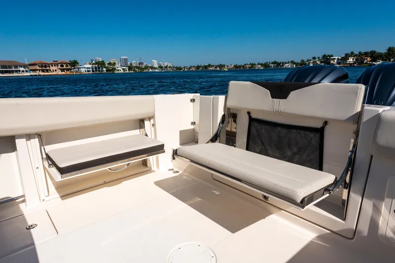 Slide: The Image of 2027 Sailfish 312 CC boat interior with foldable seating, overlooking a scenic waterfront. - 23