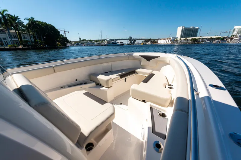 Slide: The Image of 2027 Sailfish 312 CC boat interior with seating, docked by waterfront buildings. - 15