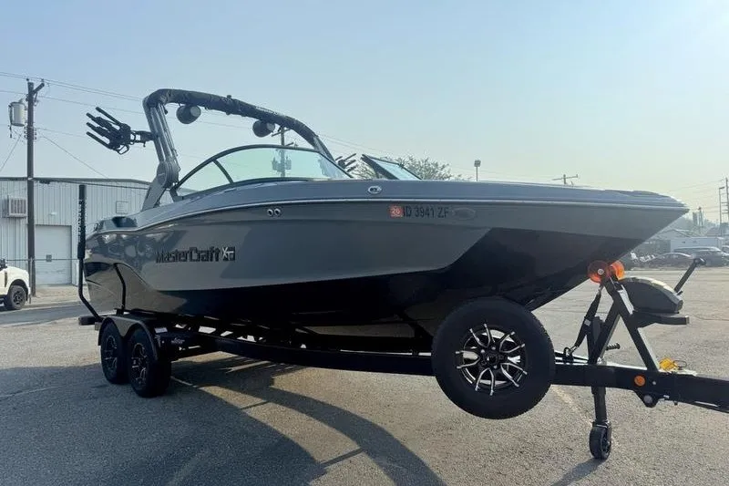 Slide: The Image of 2026 MasterCraft XT23 boat on trailer in parking lot, showcasing sleek design and modern features. - 5