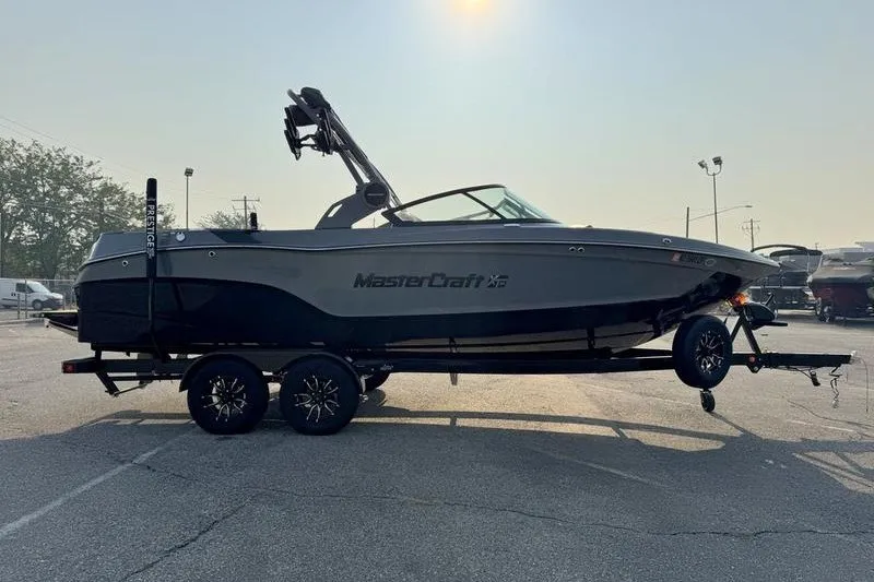 Slide: The Image of 2026 MasterCraft XT23 boat on trailer in parking lot, side view. - 7