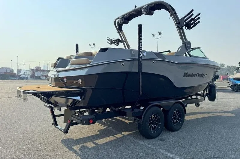 Slide: The Image of 2026 MasterCraft XT23 boat on trailer in parking lot, rear view. - 9