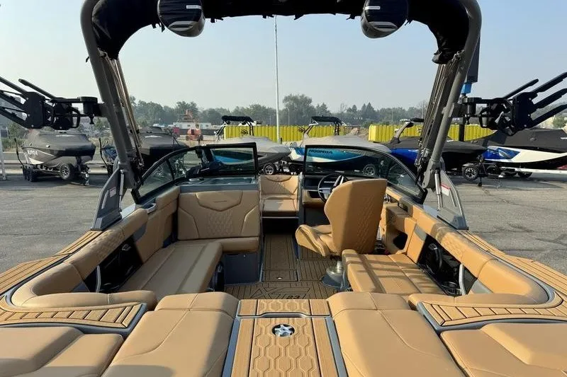 Slide: The Image of 2026 MasterCraft XT23 boat interior with tan seating and modern dashboard. - 13