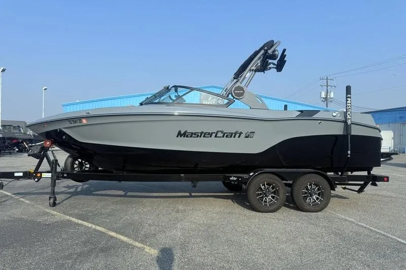 The Image of 2026 MasterCraft XT23 boat on trailer in parking lot. - 1