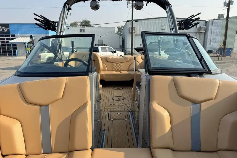 Slide: The Image of 2026 MasterCraft XT23 boat interior with tan seating and open windshield. - 15