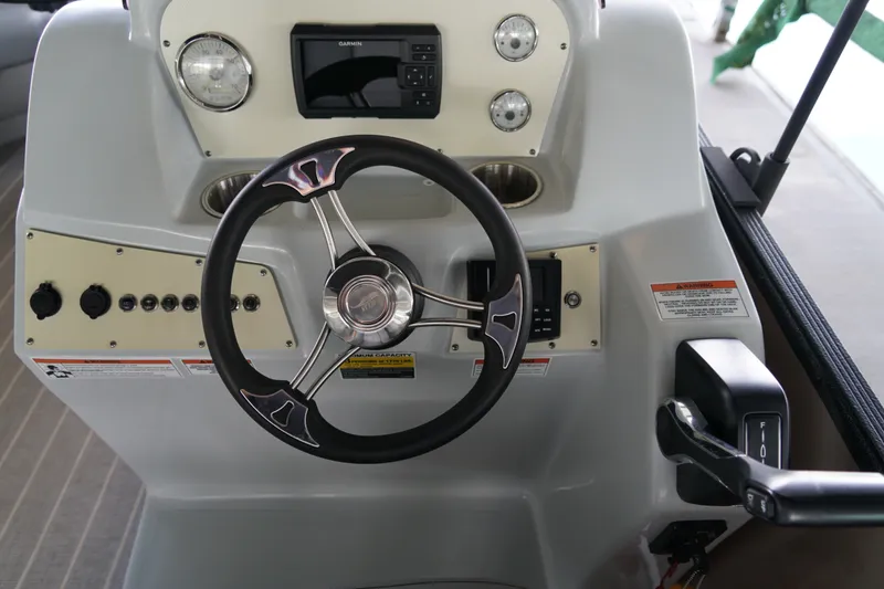 Slide: The Image of 2024 Lexington Palm Breeze Emerg boat dashboard with steering wheel and controls. - 11