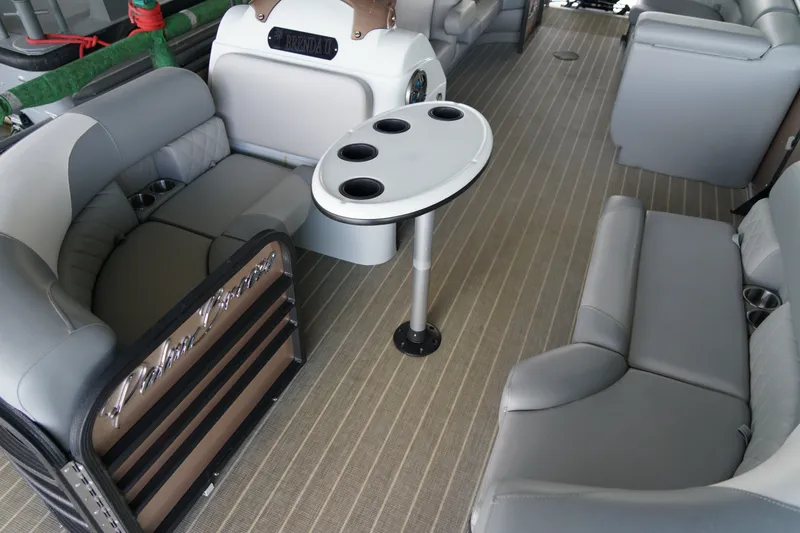 Slide: The Image of 2024 Lexington Palm Breeze Emerg boat interior with gray seating and a round table. - 13
