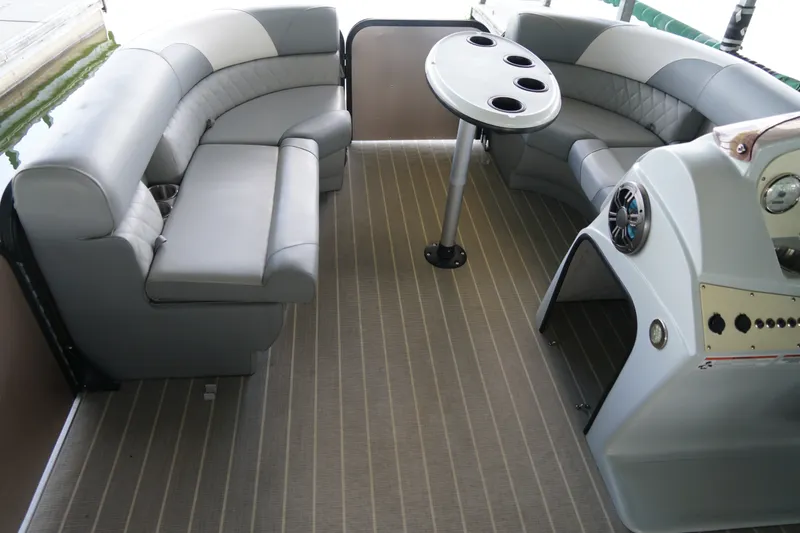 Slide: The Image of 2024 Lexington Palm Breeze Emerg boat interior with gray seating and round table. - 12