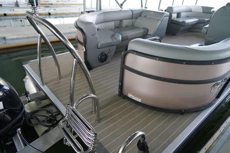 Slide: The Image of 2024 Lexington Palm Breeze Emerg pontoon boat interior with plush seating and stainless steel railings. - 8