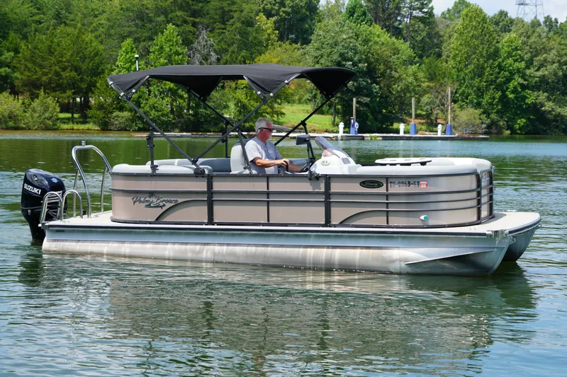 Slide: The Image of 2024 Lexington Palm Breeze Emerg pontoon boat on a serene lake. - 6