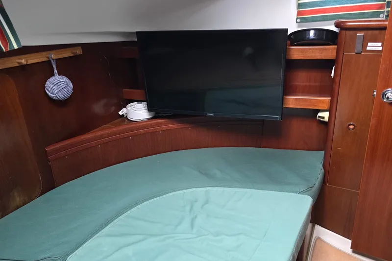 Slide: The Image of Interior of 1997 Beneteau Oceanis 36 CC with TV and green seating area. - 18