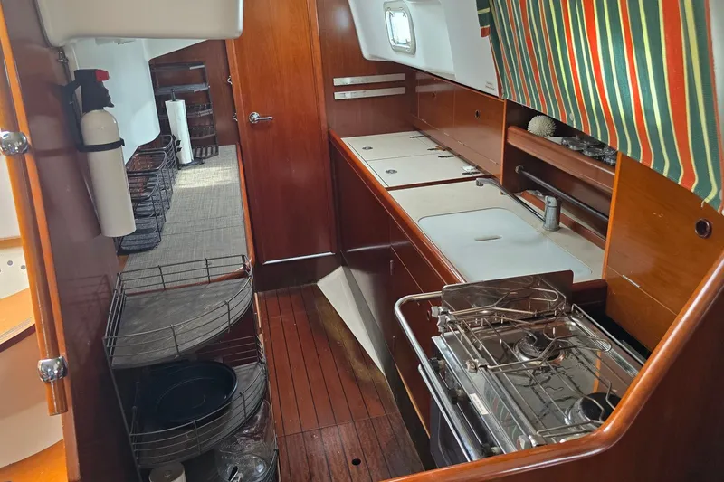 Slide: The Image of Interior of 1997 Beneteau Oceanis 36 CC sailboat, featuring a compact kitchen area. - 17