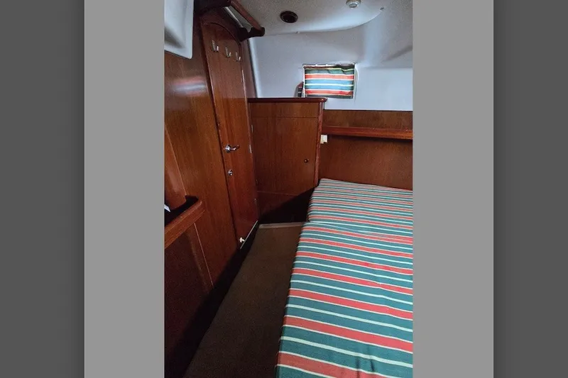 Slide: The Image of Interior cabin of 1997 Beneteau Oceanis 36 CC with striped bedding and wooden finish. - 20