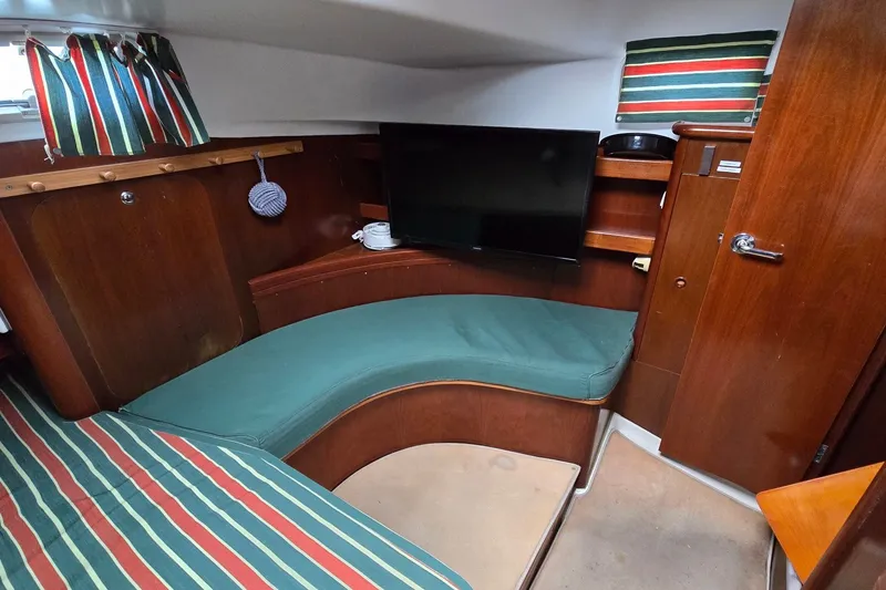 Slide: The Image of Interior of 1997 Beneteau Oceanis 36 CC sailboat with cozy seating and striped decor. - 19