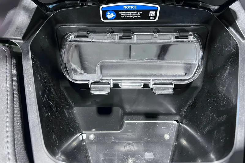 Slide: The Image of 2026 Sea-Doo RXP-X 325 glove compartment interior with clear lid and notice label. - 14