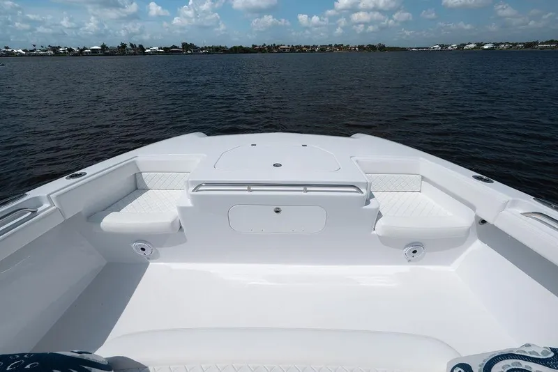 Slide: The Image of Sleek 2026 Toro Yachts Toro 42 boat deck with cushioned seating, overlooking calm waters. - 33